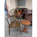 A beech wheel back armchair with a carved circular tripod table