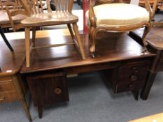 A continental teak writing desk fitted with four drawers beneath