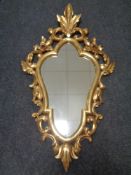 A decorative gilt framed Rococo-style wall mirror
