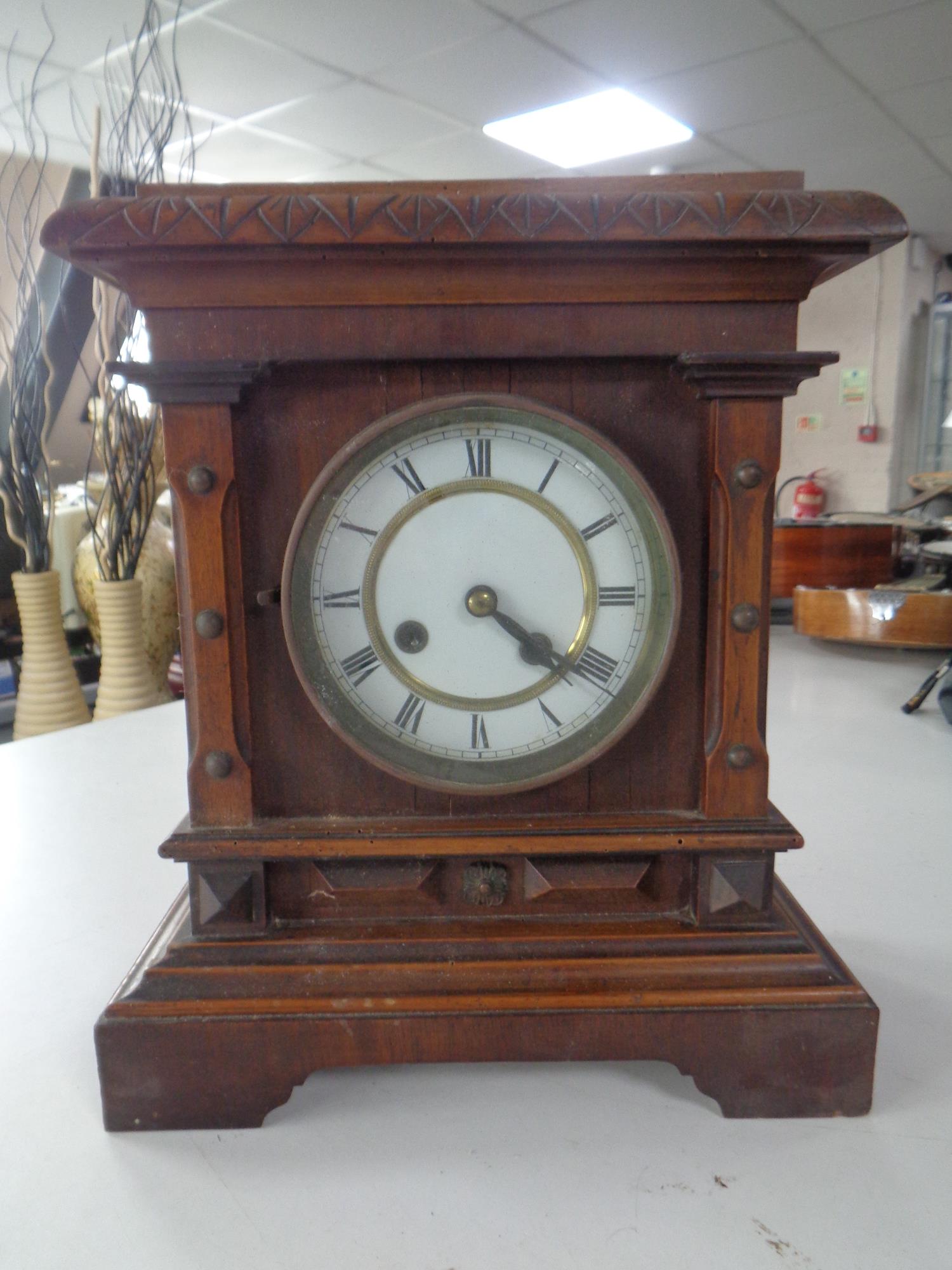 A pine cased mantel clock with enamel dial