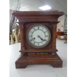 A pine cased mantel clock with enamel dial