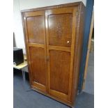 An early twentieth century panelled oak two door wardrobe