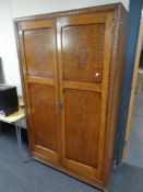 An early twentieth century panelled oak two door wardrobe