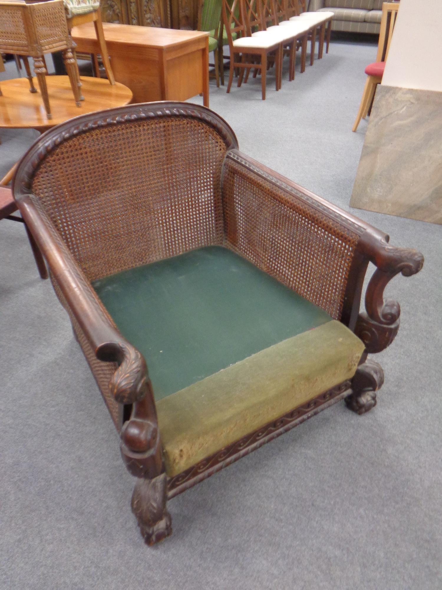 A late 19th century carved beech deep seated armchair (lacking cushion)