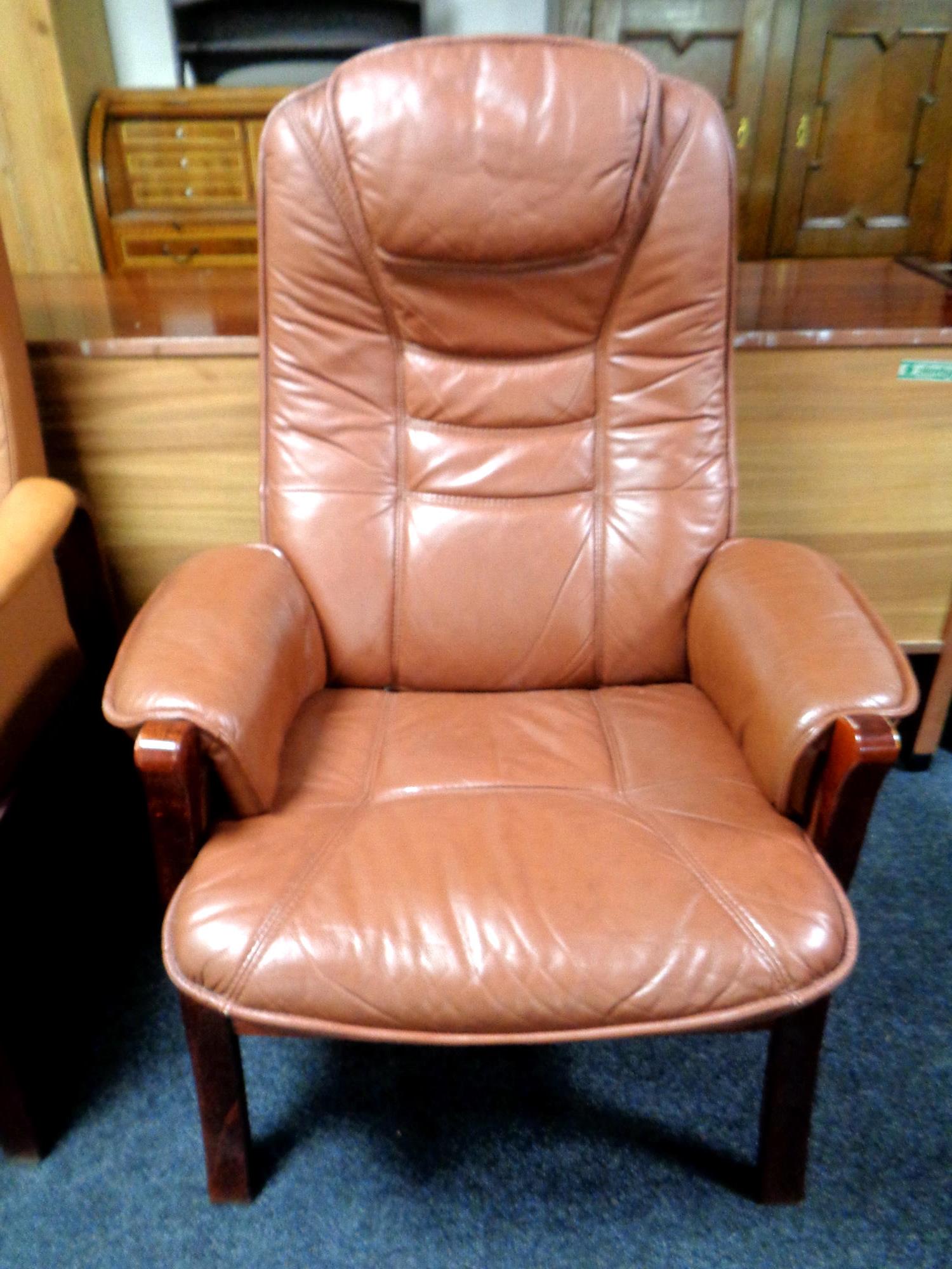 A brown leather upholstered armchair