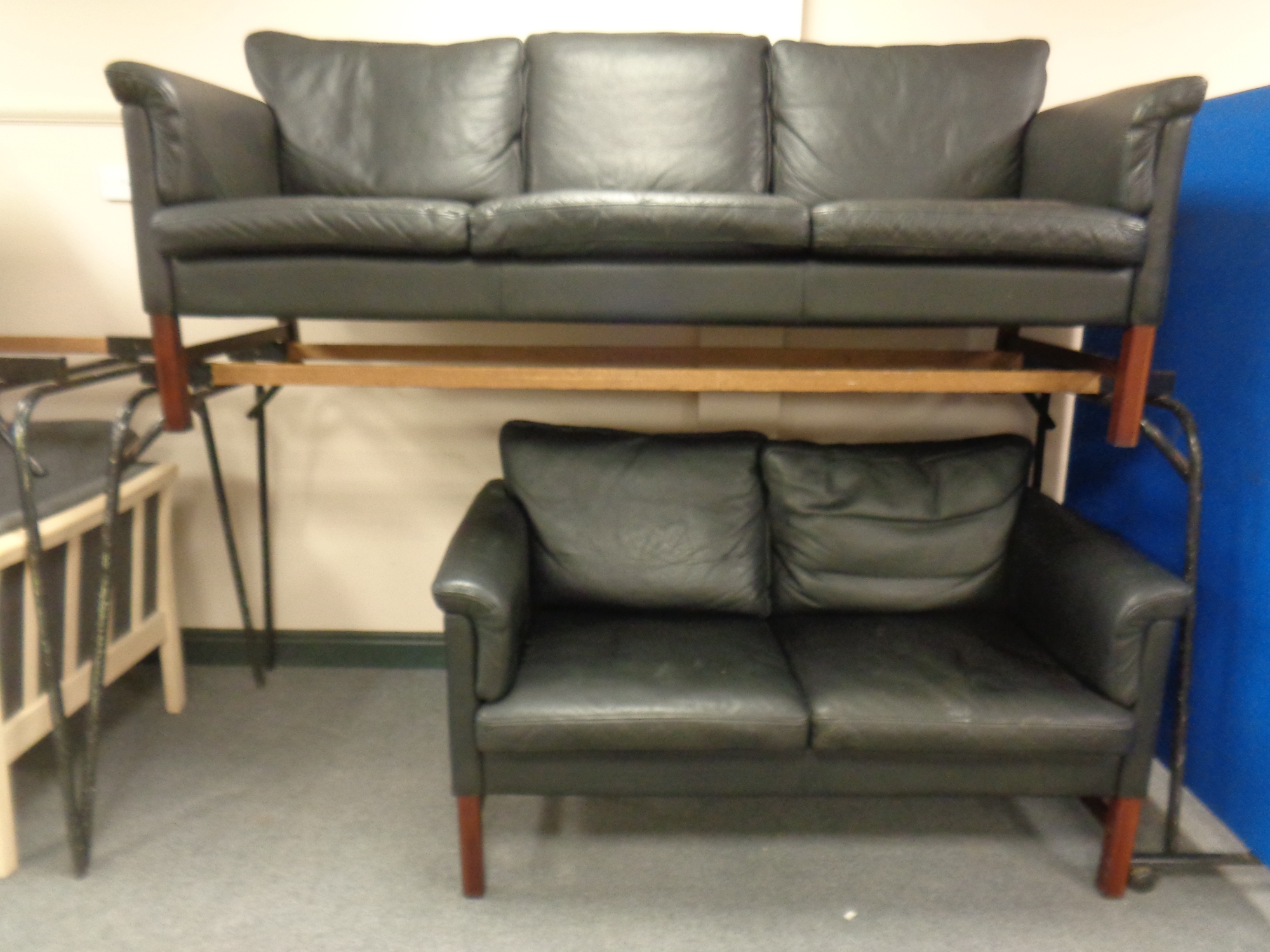 A 20th century continental stained beech framed three seater settee upholstered in black leather