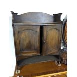 An Edwardian Arts and Crafts double door wall cabinet fitted internal drawers and shelves