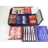 A tray of cased cutlery sets including teaspoons, servers,
