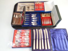 A tray of cased cutlery sets including teaspoons, servers,