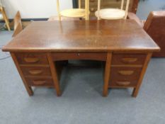 An early 20th century oak writing desk fitted with seven drawers