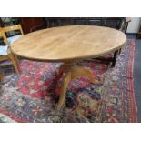A circular pine kitchen table together with a set of six chairs