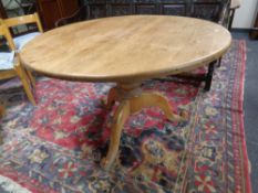 A circular pine kitchen table together with a set of six chairs