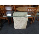 A contemporary glass topped side table on stone effect support