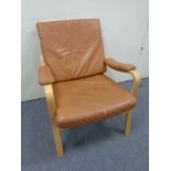 A continental beech framed arm chair upholstered in tan leather