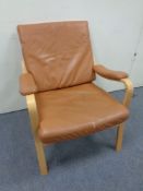 A continental beech framed arm chair upholstered in tan leather