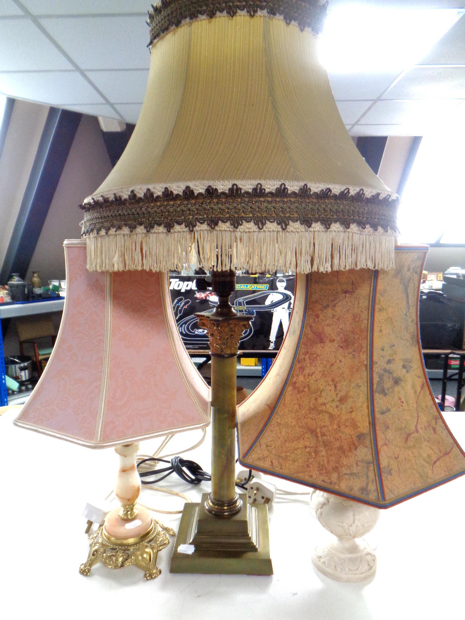 A brass and onyx table lamp with two others