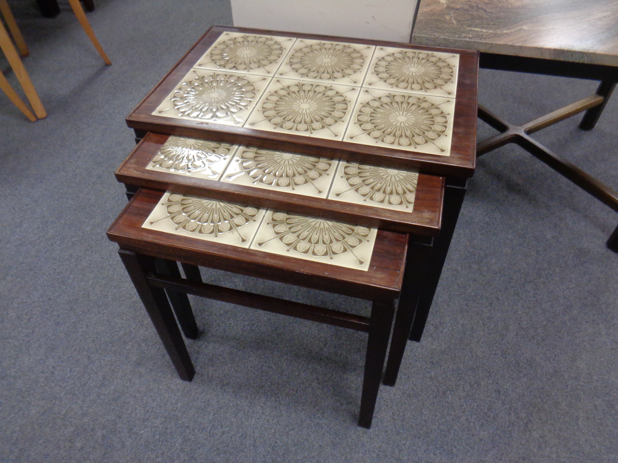 A continental rosewood veneered and tile inset nest of three tables