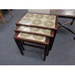 A continental rosewood veneered and tile inset nest of three tables