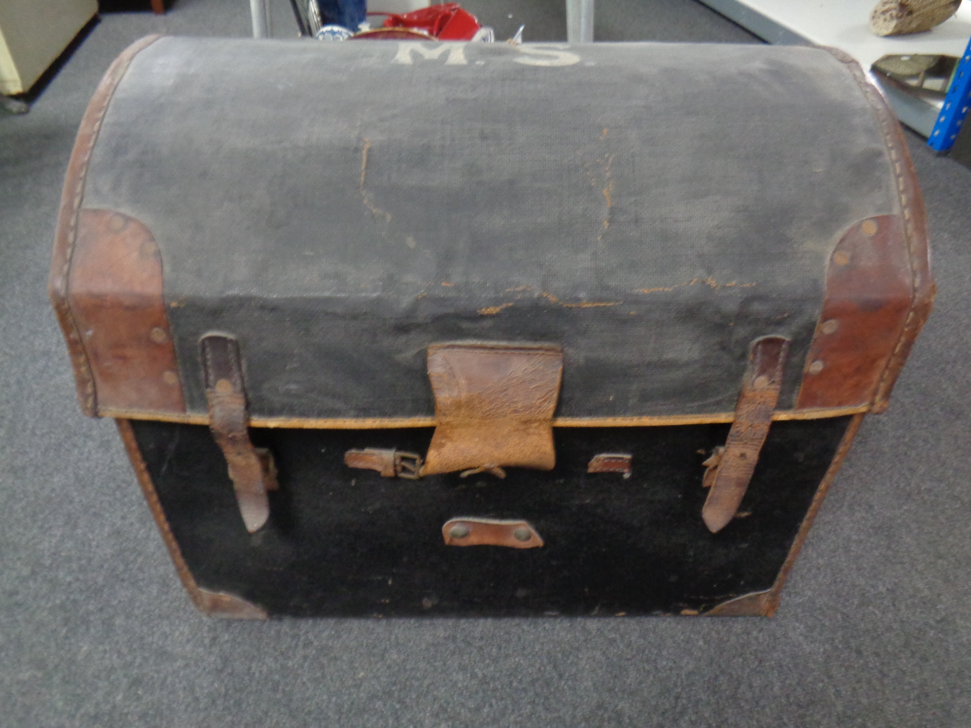An antique canvas and leather dome-topped shipping trunk.