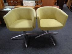 A pair of 20th century office chairs on chrome supports