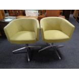 A pair of 20th century office chairs on chrome supports