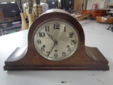 An early 20th century oak mantel clock with silvered dial