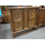 A continental beech side cabinet with carved panel doors