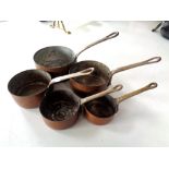 A graduated set of five miniature copper and brass saucepans