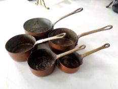 A graduated set of five miniature copper and brass saucepans