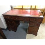 A reproduction inlaid mahogany twin pedestal nine drawer writing desk with tooled leather inset