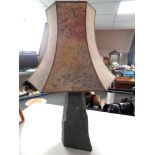 A contemporary table lamp on naturalistic stone support