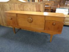 A 20th century teak low sideboard with fitted cupboards and drawers beneath