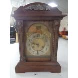 An oak mantel clock with brass and silvered dial