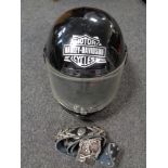 A Harley Davidson belt buckle with leather belt and a motorcycle helmet