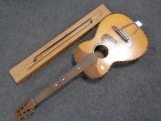 A marquetry inlaid acoustic guitar together with a violin bow in a pine box.