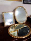 Two gilt framed dressing table mirrors together with a further gilt framed oval bevel-edged mirror.