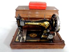 A vintage Singer hand sewing machine in case.