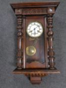 An antique mahogany cased 8 day wall clock with brass and enamel dial.