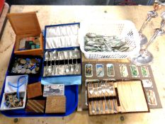A tray and a basket containing assorted coinage, needle packets, treen boxes, plated candlesticks,