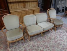 A three piece Ercol elm and beech lounge suite comprising of two seater settee and two armchairs