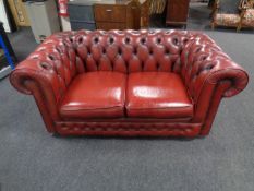 A Chesterfield red leather two seater club settee