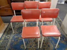 A set of five tubular metal kitchen chairs upholstered in red vinyl.