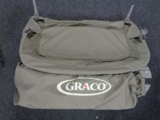 A Graco travel cot in carry bag.