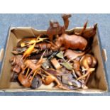A box containing a quantity of tourist carvings including animal figures, a desk stand,