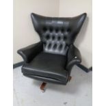 A 1960's vintage G-plan swivel armchair in black vinyl