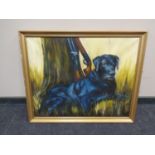 J E Wigston : A black labrador and shotguns beside a tree, oil-on-board, in gilt frame.