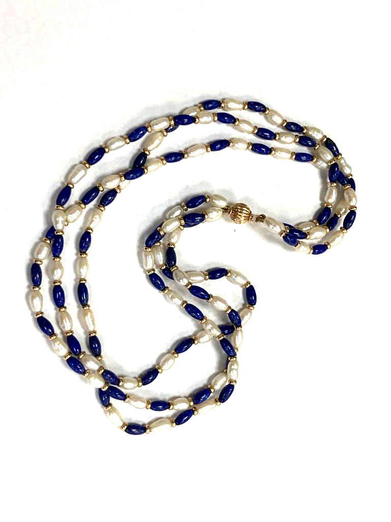A triple strand pearl and lapis lazuli necklace with gold catch and gold beads