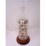 A set of 28 Royal Crown Derby china thimbles on display stand in the form of a decanter.