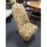 A 20th century nursing chair upholstered in a floral brocade fabric.