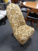 A 20th century nursing chair upholstered in a floral brocade fabric.